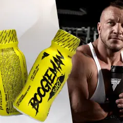 Mężczyzna z potężną sylwetką trzyma shaker, obok niego żółte shoty "Boogieman Shot" - napój dla sportowców.
