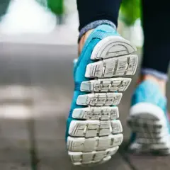 Niebieskie buty sportowe na chodniku, gotowe na szybki marsz czy bieganie.