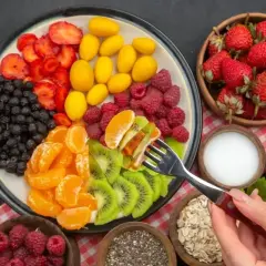 Kolorowa taca z owocami: truskawki, jagody, kumkwaty, maliny, mandarynki i kiwi. Idealna na śniadanie wspierające spalanie tłuszczu.